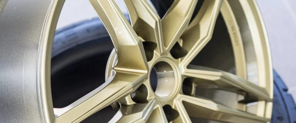 Detail zlatě lakovaného vícepaprskového ALU kola s pneumatikou